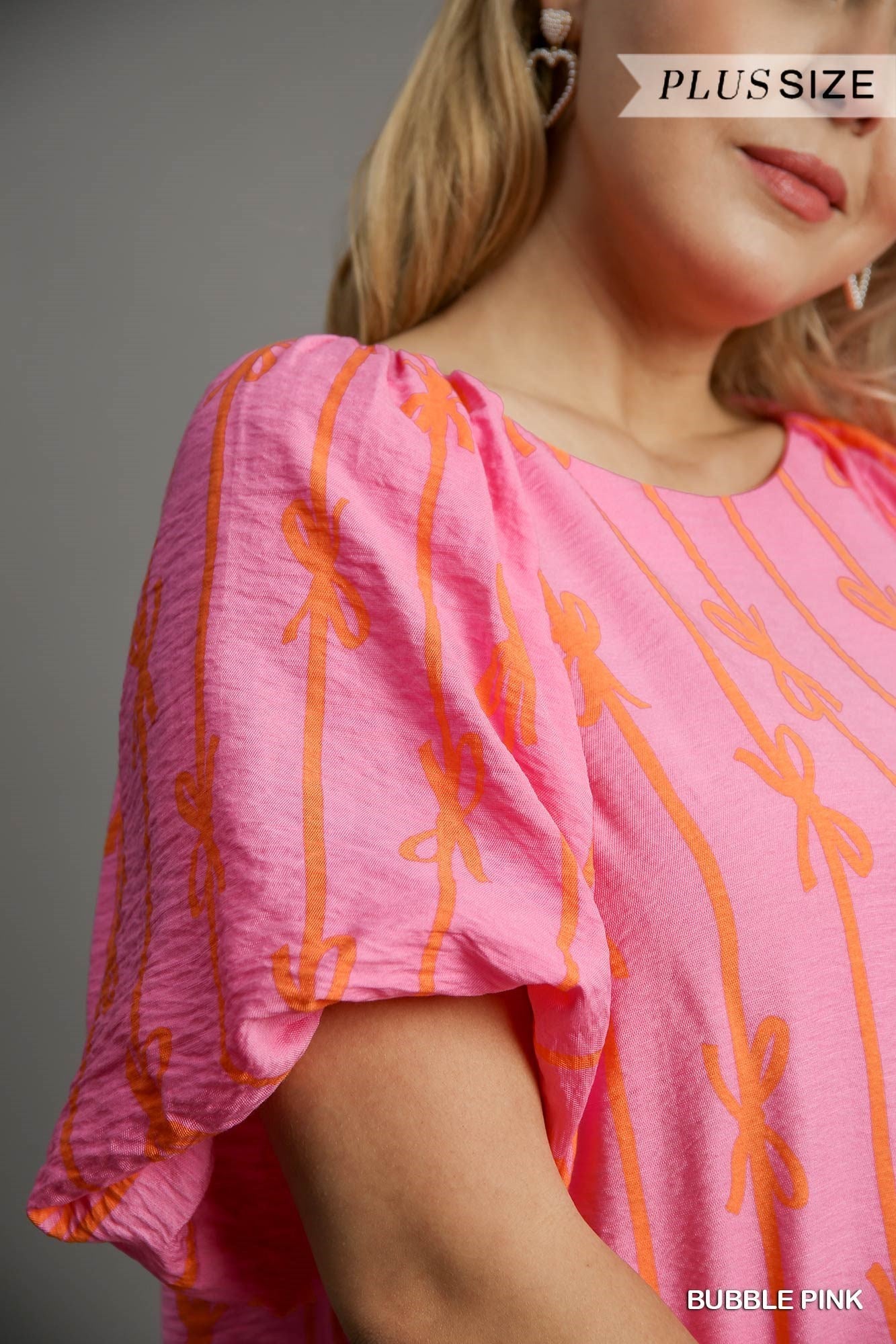 Ribbon Print Puff Sleeve Top in Bubble Pink with trendy orange ribbon patterns and puff sleeves. Available sizes: Plus Size.