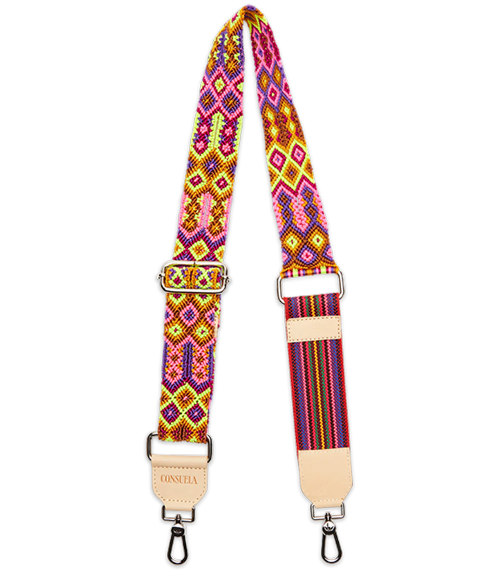 The Consuela Woven Crossbody Strap, Bubbles, features vibrant geometric patterns in pink, yellow, and orange. It has metal clips at each end and a beige leather patch with text. Adjustable length for customizable fit.