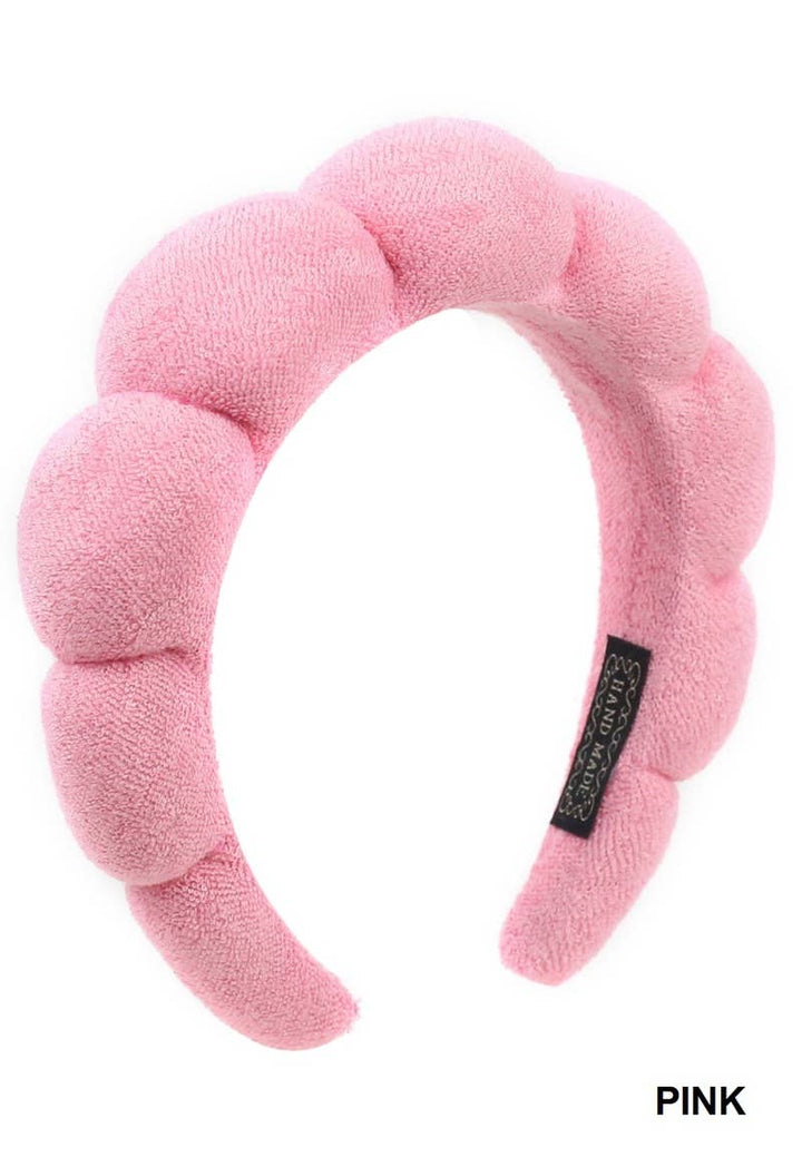 Light pink plush terry hair headband with bubble texture, black label, "PINK" in black on corner. Sizes: S/M, M/L.