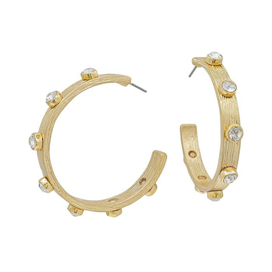 Gold hoop earrings with a textured finish and spaced clear round gemstones. Available in small, medium, and large sizes.