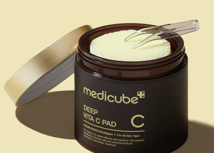 Open MEDICUBE Deep Vita C Pads jar with yellow pads, clear tweezer, and gold lid. Available in 70-pad size.