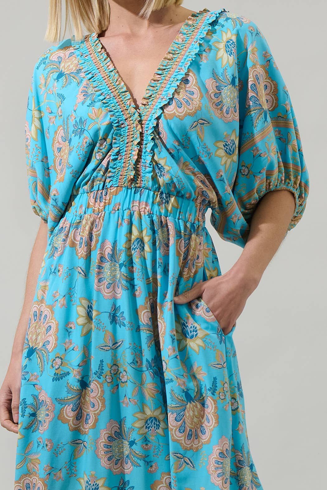 Raven Floral Hant V-Neck Midi Dress in blue floral pattern with ruffled neckline, puff sleeves, elastic waist. Sizes XS-XL.
