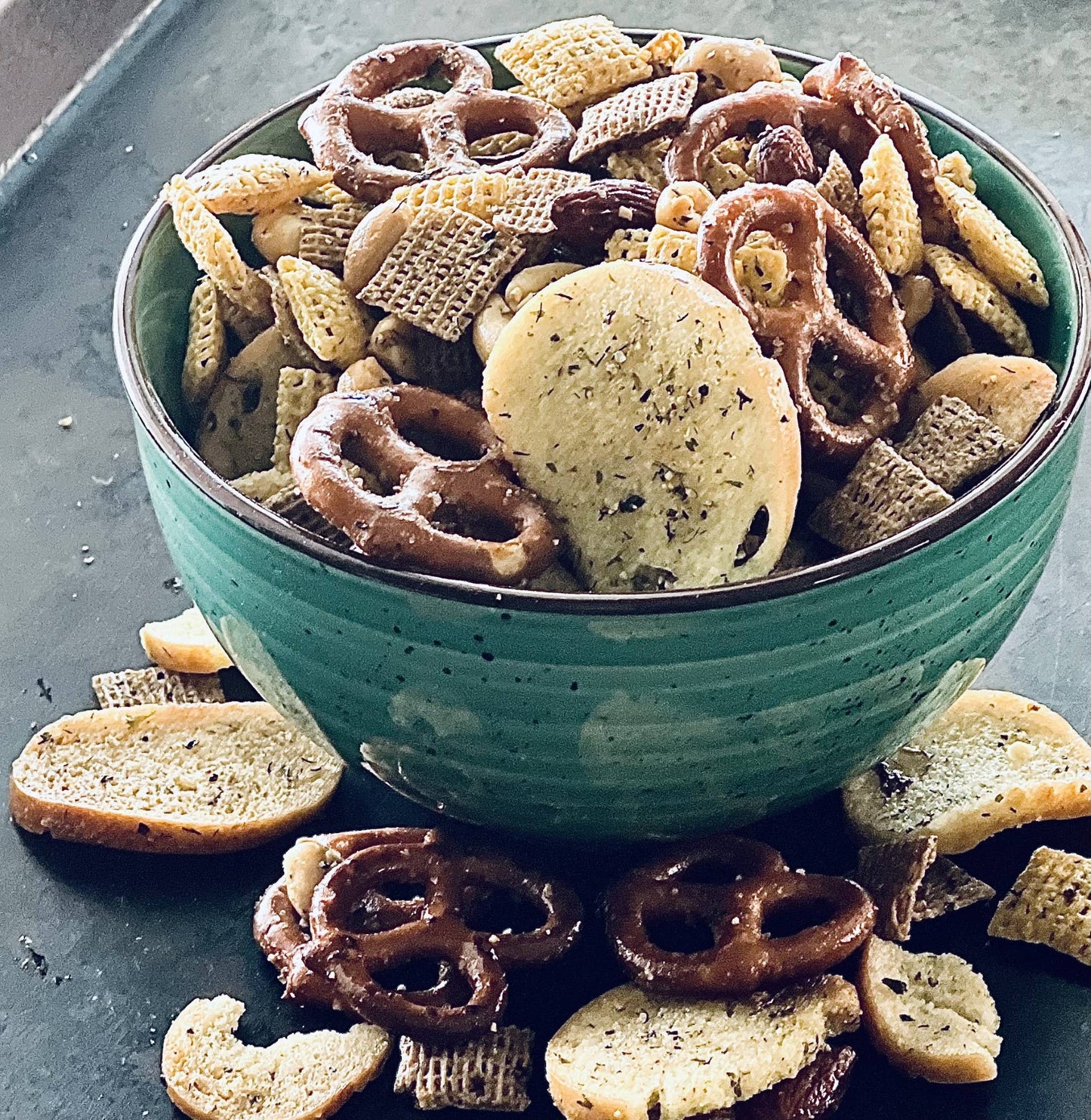 Snack mix of pretzels, cereal squares, bagel chips, and nuts for Buttermilk Ranch Seasoning. Available in small and large sizes.