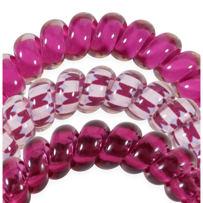 Three Merlot after Midnight Large Hair Ties: two shiny magenta, one clear with magenta zigzag. Available in large size for secure, crease-free hold.