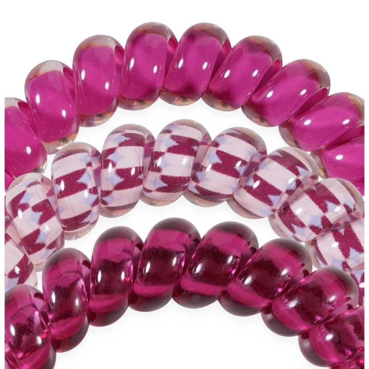 Three Merlot after Midnight Large Hair Ties: two shiny magenta, one clear with magenta zigzag. Available in large size for secure, crease-free hold.