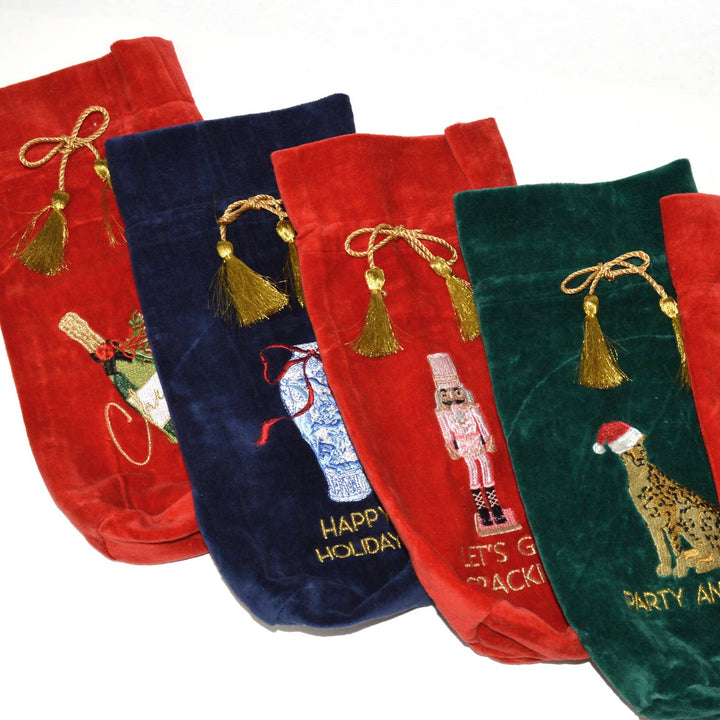 Five velvet wine bags, including the Ginger Jar Blue Embroidered Wine Bag, in red, blue, and green, each with a gold drawstring tassel and festive embroidery.