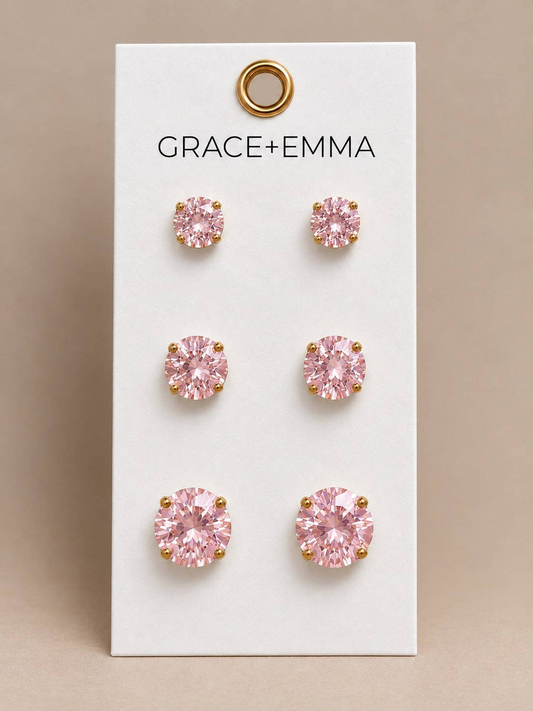 Three pairs of round, light pink 3-stone earrings in graduated sizes.