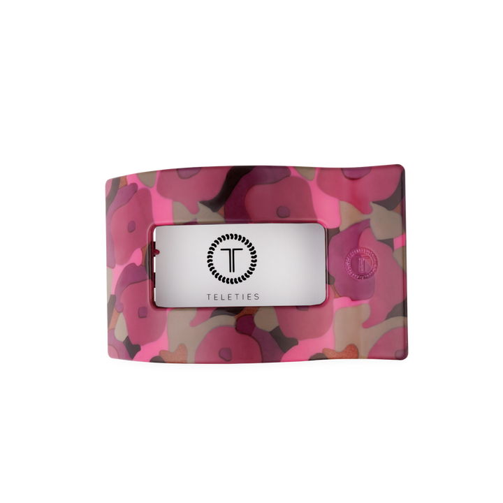 Medium flat rectangular hair clip with wavy design, pink and purple floral pattern, and a central clear window showing the black TELETIES logo. Available in medium size.