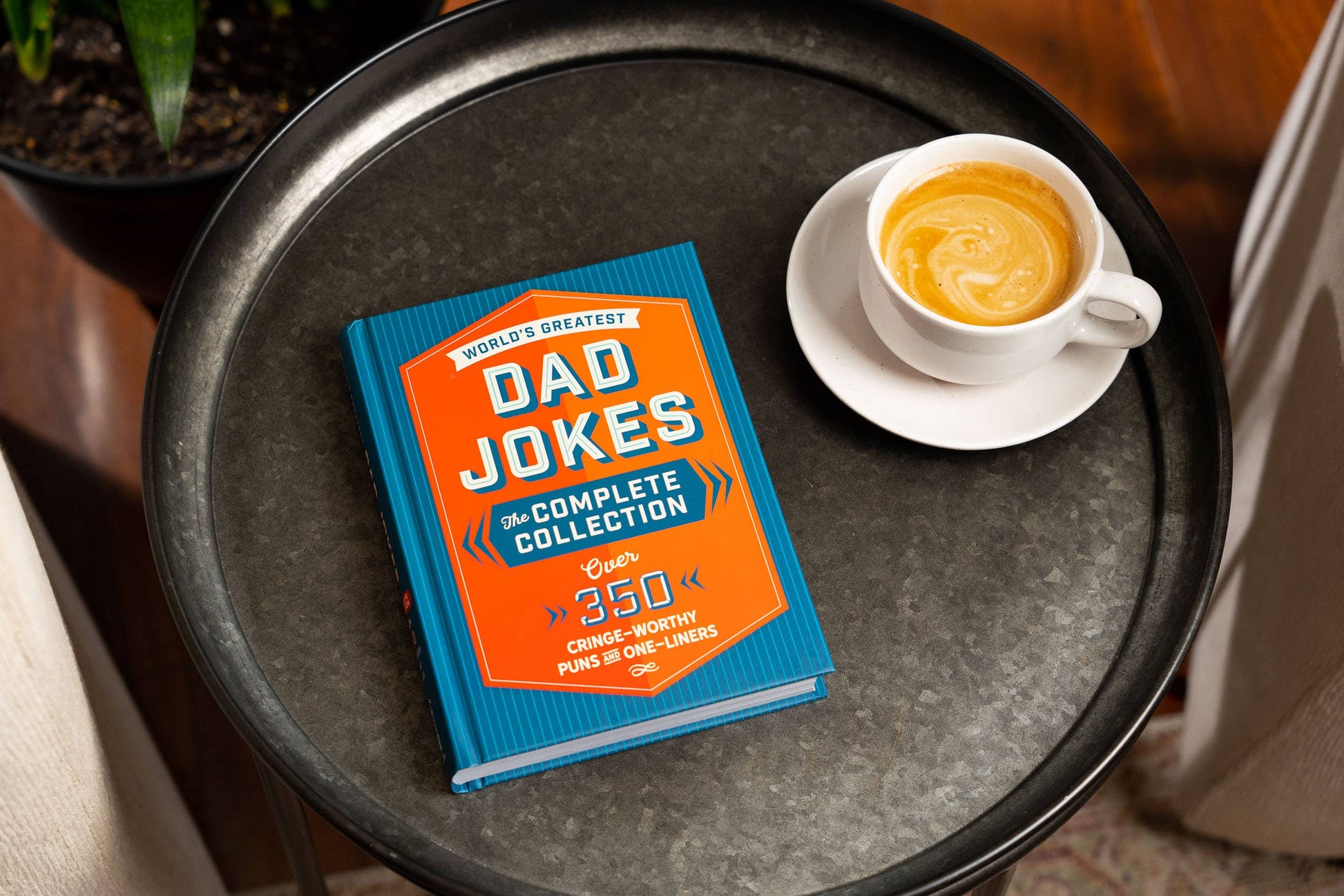 Family-friendly hardcover book, "World’s Greatest Dad Jokes," blue and orange cover; available in standard size.