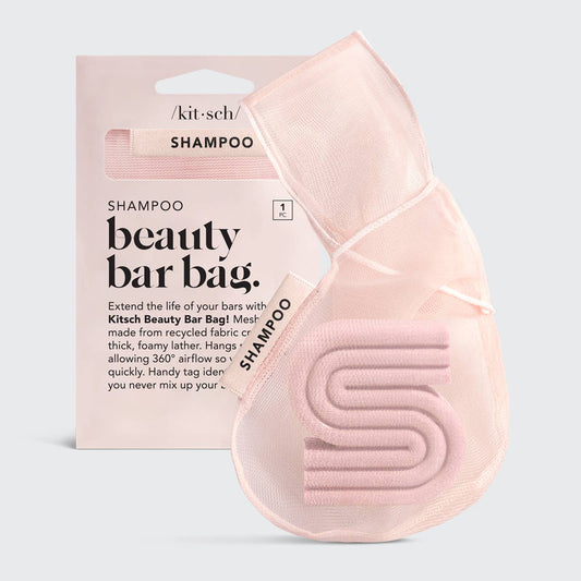 Light pink mesh zippered bag labeled "SHAMPOO," with curved design and fabric loop. Sizes available: standard and large.