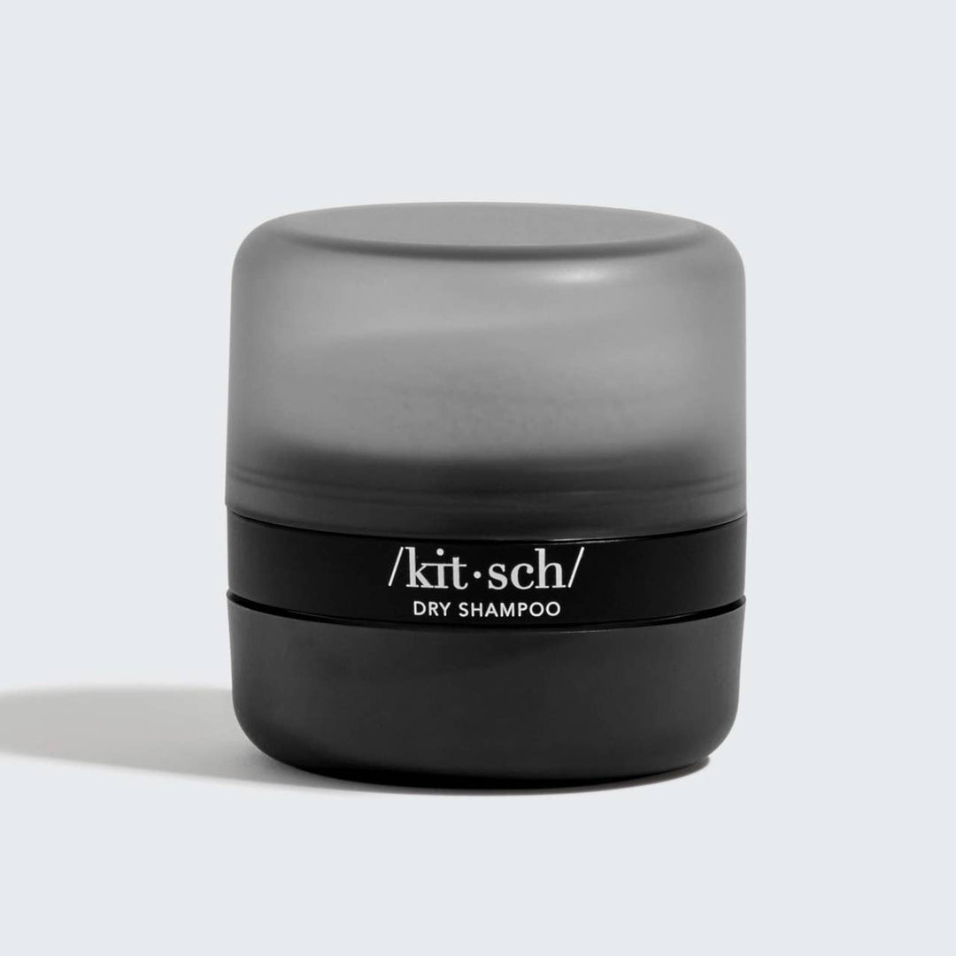 Matte black container, frosted gray cap, labeled for dark-tinted dry shampoo. Available in 1.5oz and 3oz sizes.