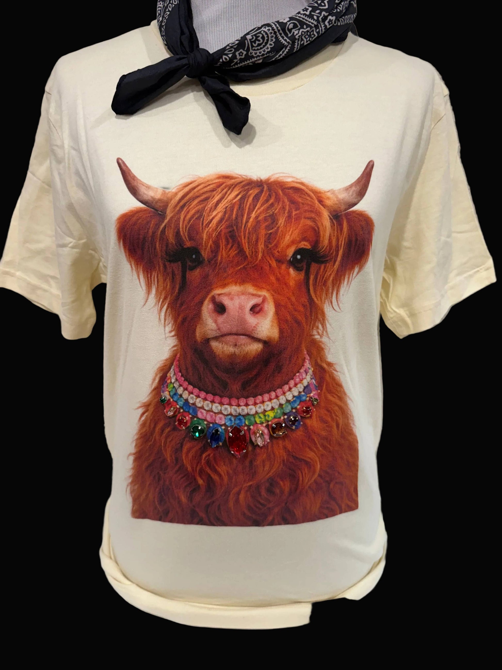 Light pink crewneck T-shirt, size 2XL, called "Jeweled Collar Highland Calf," features a graphic of a Highland calf with a colorful jeweled collar. No additional bling. Available in sizes 2XL and colors white, natural, or light pink.