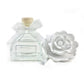 Clear glass bottle with wooden cap, white ribbon, and sculpted ceramic flower diffuser; sizes available: 100ml, 200ml.