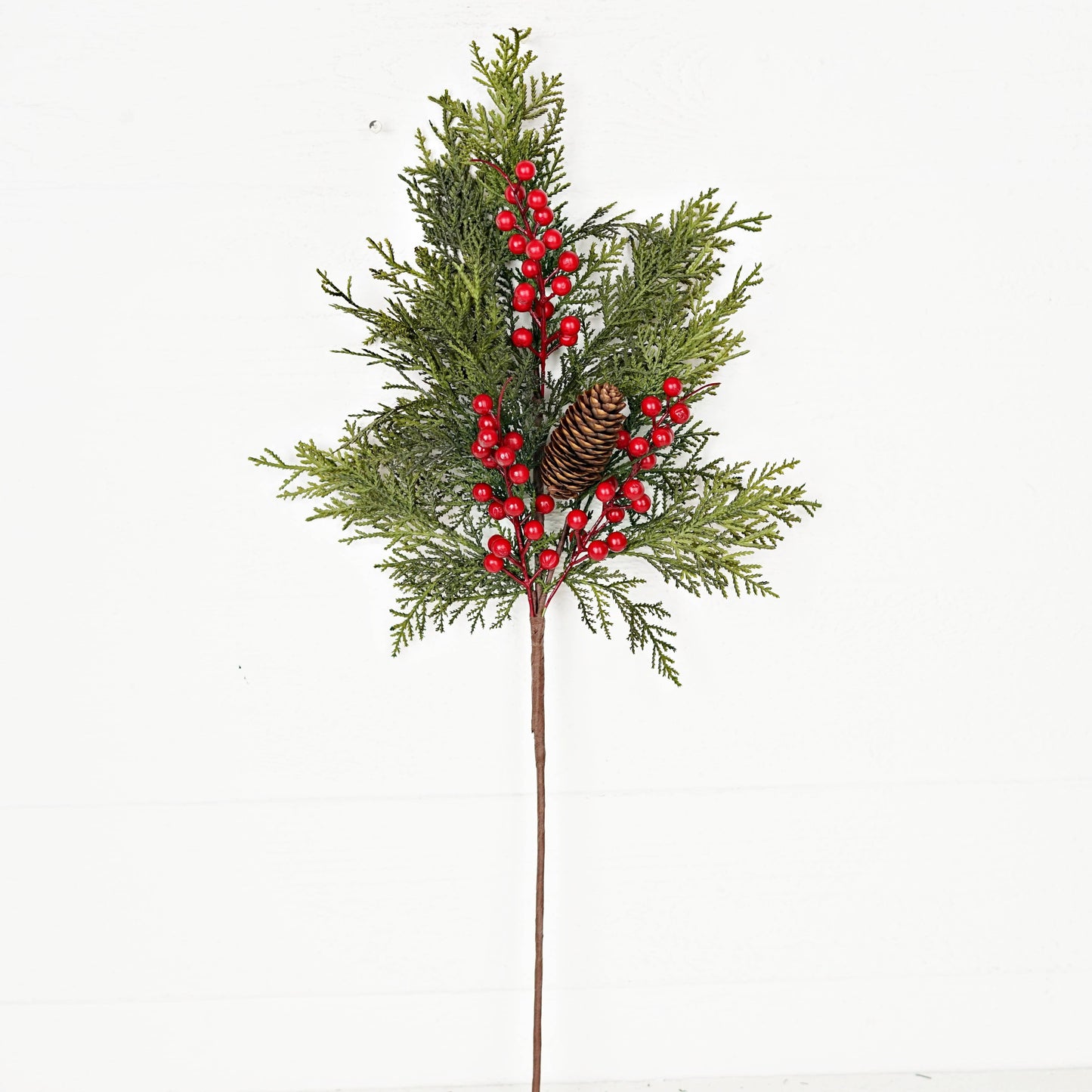 29in branch with lifelike cedar, green pine needles, red berries, and a brown pinecone on an extended brown stem. Only available in 29in size.