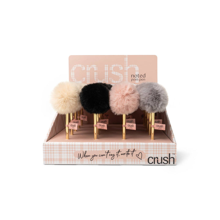 Crush Noted Pom Pens with fluffy pom-pom toppers in beige, black, light pink, or gray and sleek goldtone barrels. Black ballpoint ink. Available in standard pen size only.