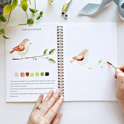 Animals Watercolor Workbook with spiral binding, showing finished and unfinished bird paintings. Sizes: 8x10 in, 9x12 in.