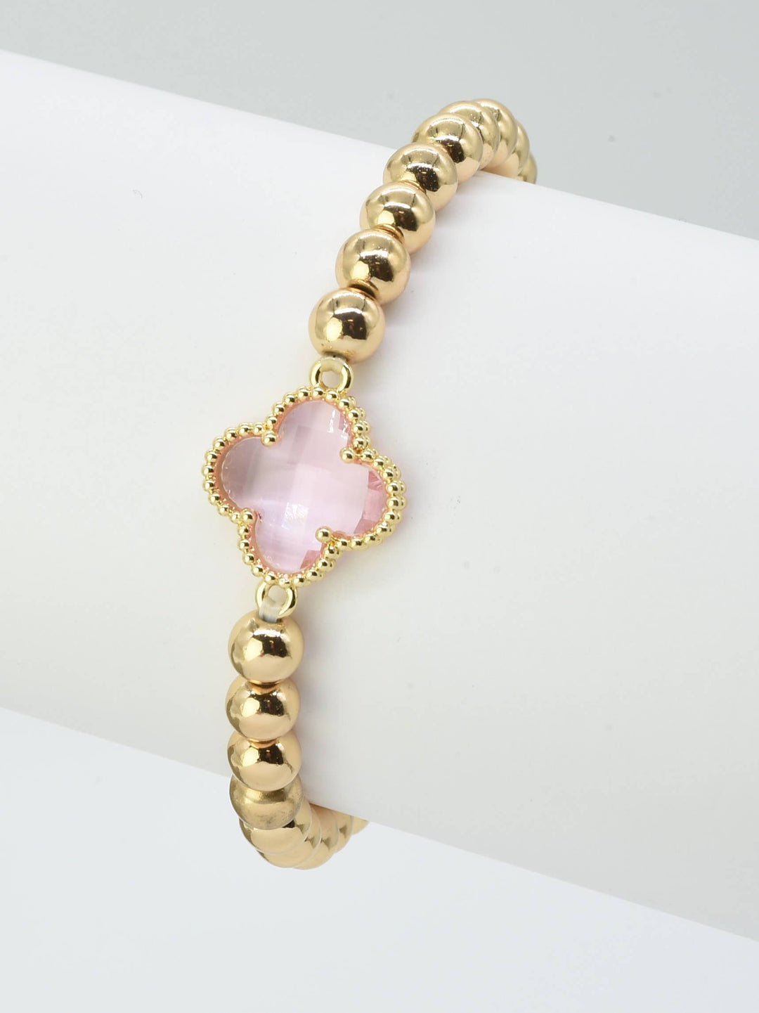 Gold beaded bracelet with pink crystal clover charm in gold frame. Sizes available: S, M, L.