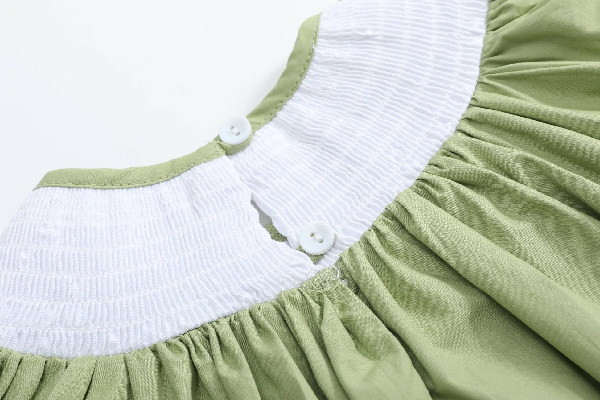 Light green Pistachio Green Mallard Duck Smocked Bishop Dress with a white textured yoke and two white buttons at the back neckline. Gently gathered soft material below the yoke. Available in size 4T.