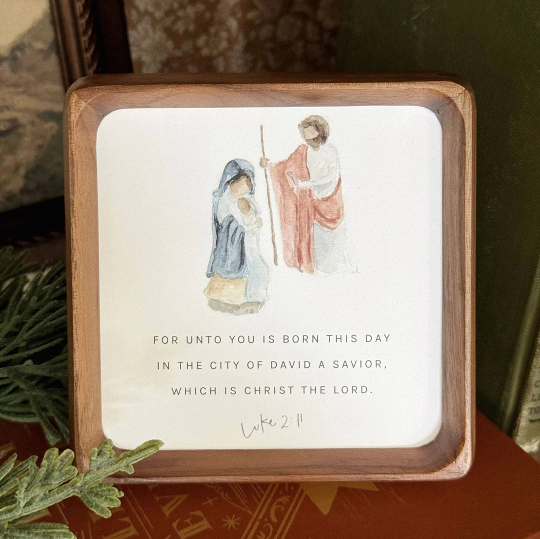 Wooden-framed sign with Mary, angel, and Luke 2:11 verse. Available in 8"x10" and 12"x16".