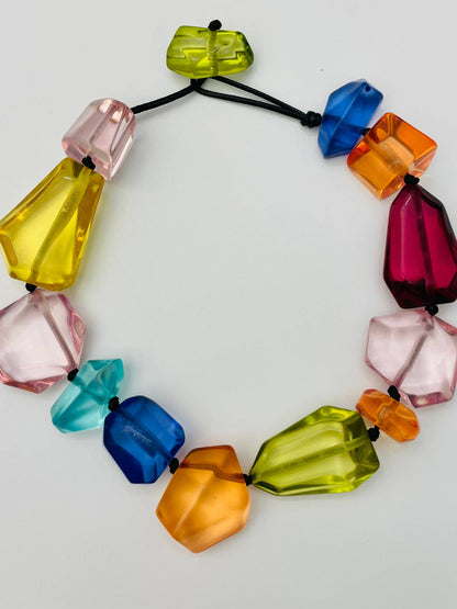 CHIC - Clear Stone Necklace (multi) NK890: Acrylic necklace with large, irregular beads in yellow, pink, blue, red, orange, and green on a black cord. Sizes available: One size.