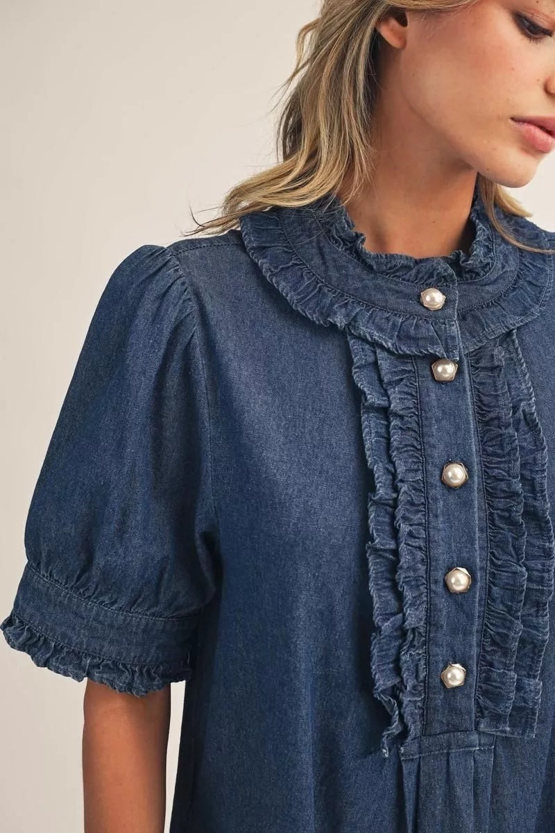 Dark blue Darcy Ruffle Denim Dress with short puffed sleeves, ruffle-trimmed high collar, and pearl-style button-front placket. Available in various sizes.