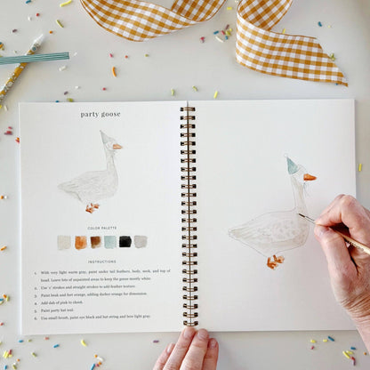 Celebrate watercolor workbook, open to a “party goose” page with step-by-step painting instructions and a hand-drawn goose in a party hat. Available in multiple sizes.