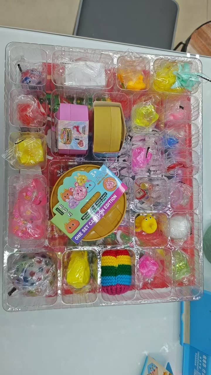 Squishy Mystery Calendar Countdown Days with a clear plastic tray, twenty-four individual compartments, wrapped toys, and a central mystery box.