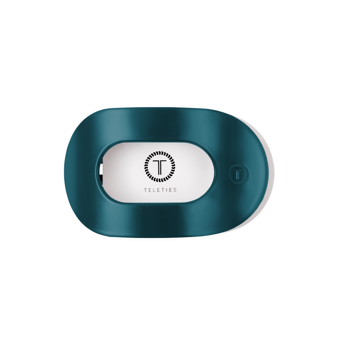 Teal “Teal With It Medium Flat Round Hair Clip” by TELETIES, oval-shaped with a rectangular center opening, features the TELETIES logo and name inside; available in medium size.
