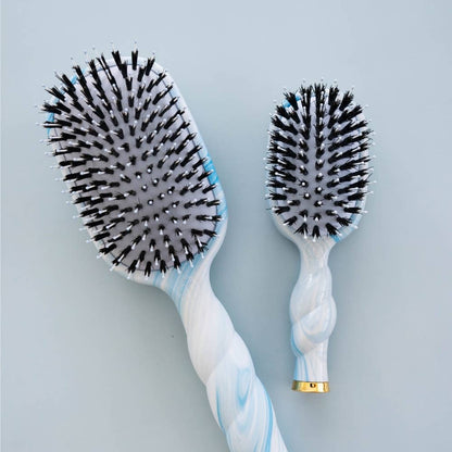 Mini Boar Brush from Tide & True features a compact white and blue design with black bristles, available in small and large sizes.