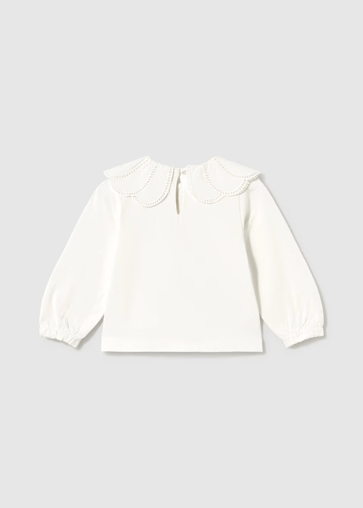 White long-sleeve blouse with a scalloped embroidered Peter Pan collar, eyelet trim, back button keyhole, and gathered balloon cuffs. Available in sizes 2T-6Y.