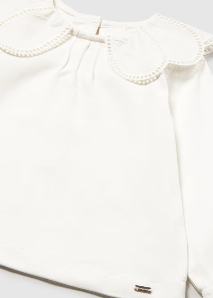 White blouse with scalloped Peter Pan collar, eyelet trim, smooth fabric, balloon sleeves, and subtle metallic brand tag near hem. Available in sizes 2T-6.