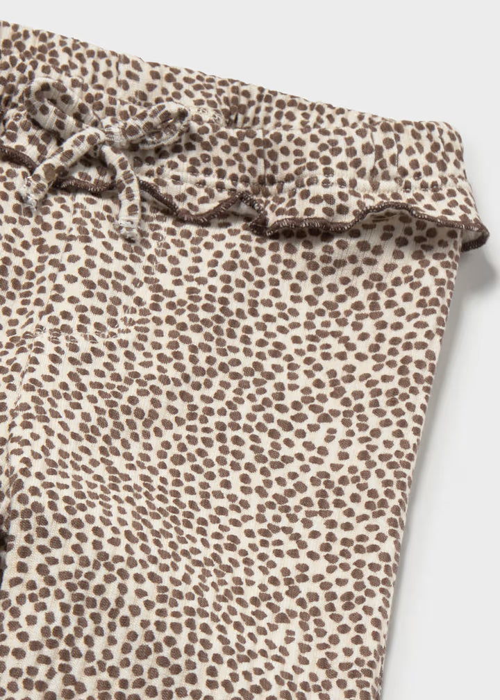 Light beige ribbed flare leggings with brown micro dot pattern, ruffled waistband, and drawstring tie. Available in child sizes.