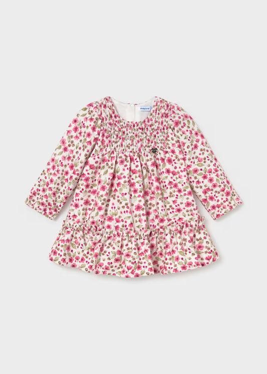 Baby Girl Floral Printed Velvet Dress with green leaves and pink flowers on white, long sleeves, smocked bodice, ruffled hem. Available in sizes 0-24 months.