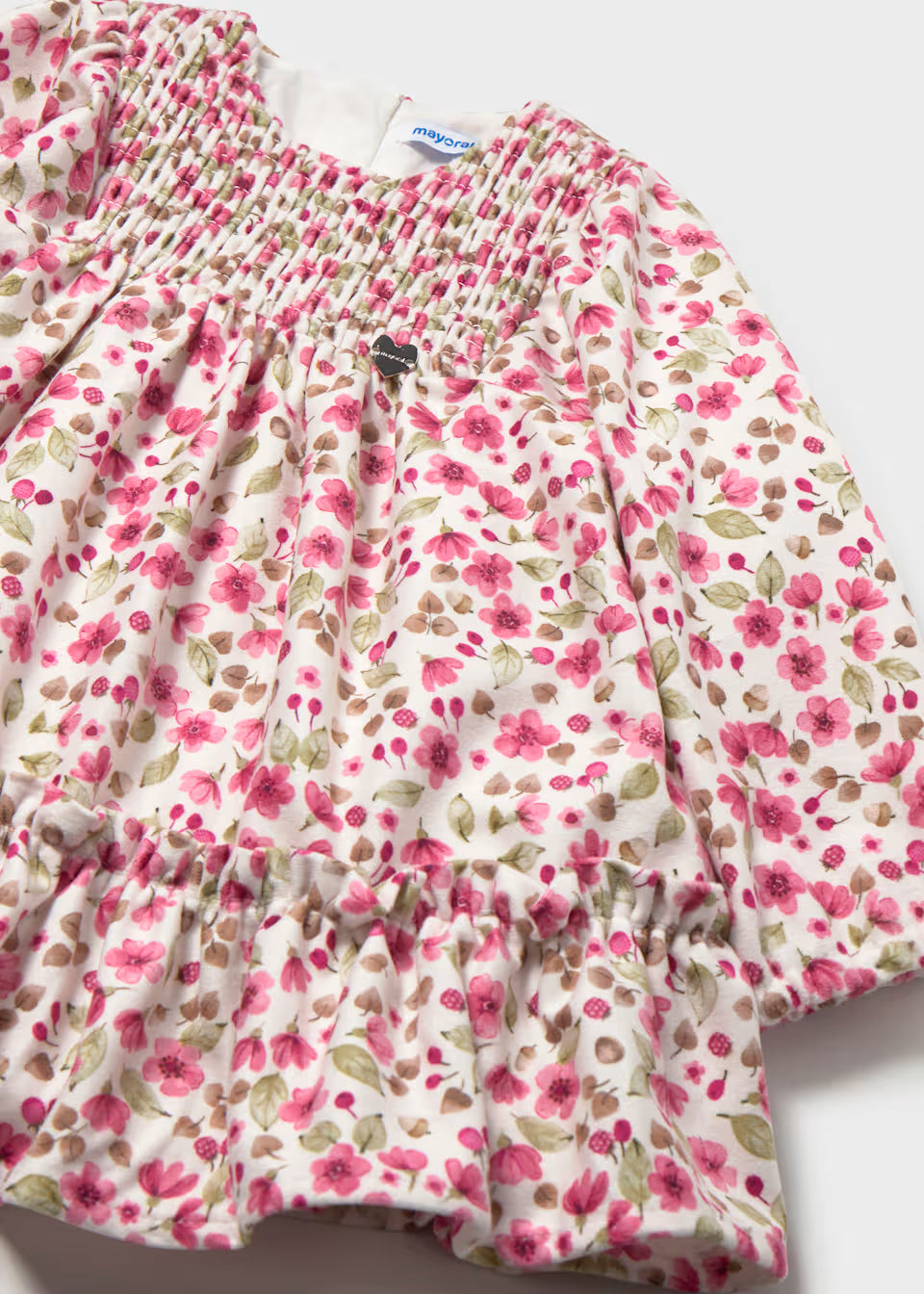 Velvet baby girl dress with long sleeves, pink floral print, smocked bodice, and ruffled hem. Available in sizes 0-24 months.