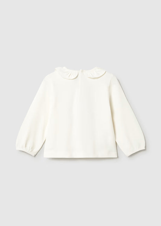 White, loose fit long sleeve T-shirt with elasticized cuffs and a ruffled Peter Pan collar. Available in sizes 80-120.