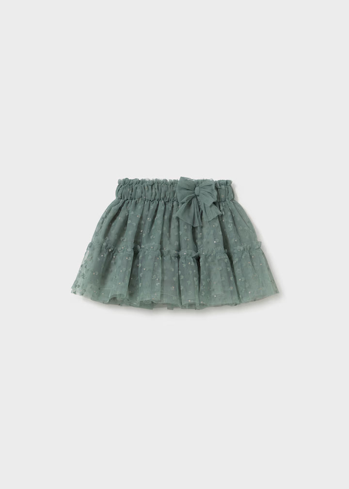 Laurel Green Baby Tulle Skirt with elastic waistband, decorative bow, embroidered hearts, small dotted pattern, and layered ruffle design. Available in sizes 0-3M, 3-6M, 6-12M, and 12-24M.