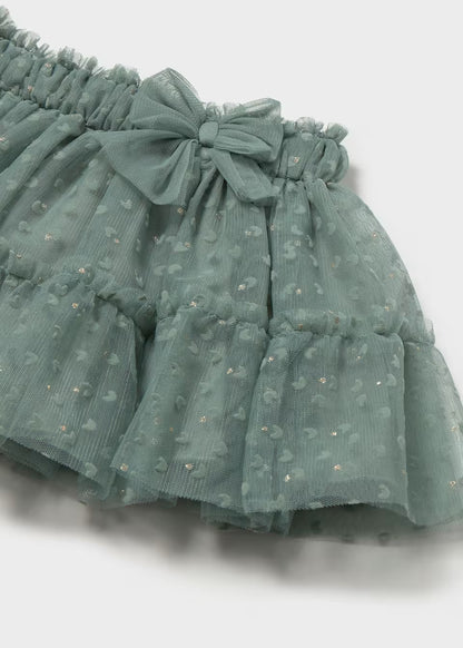 Laurel Green Baby Tulle Skirt with ruffles, elastic waistband bow, glittery polka dots, and embroidered hearts. Available in sizes 0-3M to 24M.