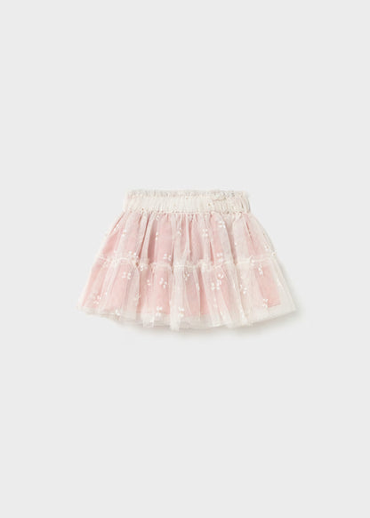 Pink tulle skirt with white floral embroidery, embroidered butterflies, layered design, and elastic waistband. Available in sizes 2T-5T.