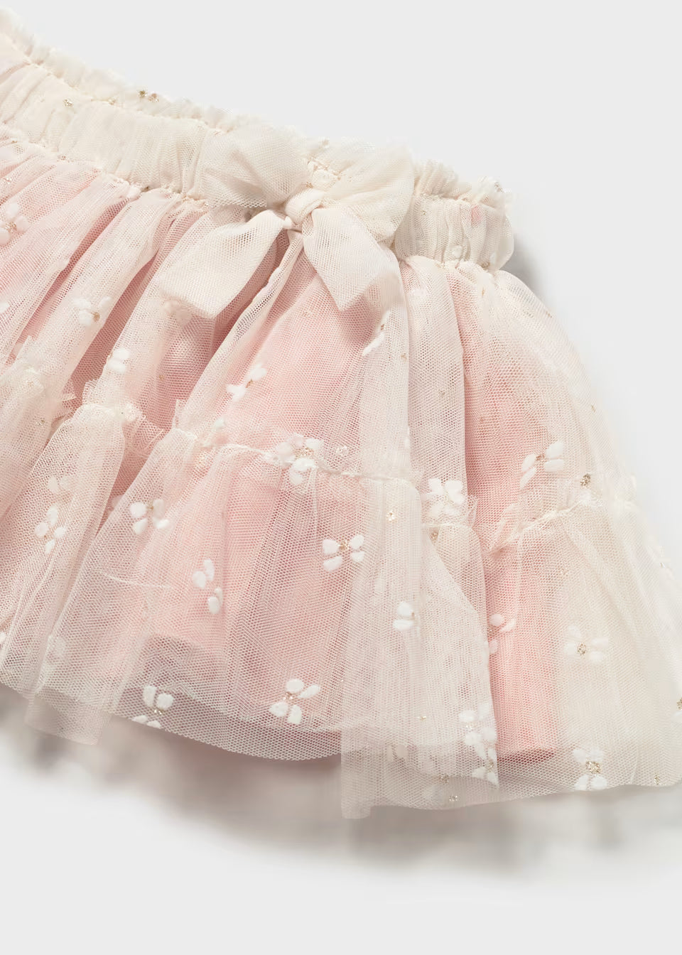 Light pink ruffled tulle baby skirt with white embroidered flowers, delicate butterflies, and a decorative waistband bow; available in sizes 0-24 months.