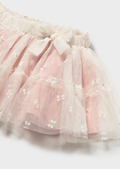 Light pink ruffled tulle baby skirt with white embroidered flowers, delicate butterflies, and a decorative waistband bow; available in sizes 0-24 months.