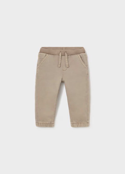 Beige twill jogger pants for toddlers with elastic waistband, drawstring, side pockets, and elastic cuffs. Available in sizes 2T-5T.