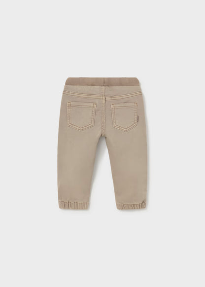 Beige twill jogger pants with elastic waistband and cuffs, easy pull-on style, and two stitched back pockets. Available in sizes 2T-5T.