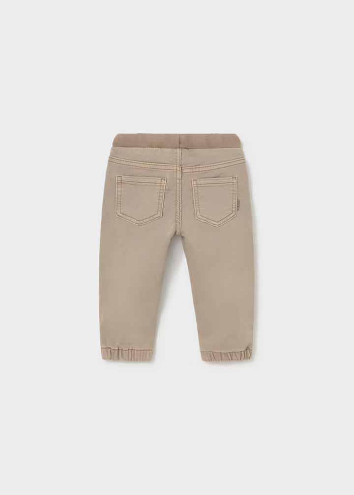 Beige twill jogger pants with elastic waistband and cuffs, easy pull-on style, and two stitched back pockets. Available in sizes 2T-5T.