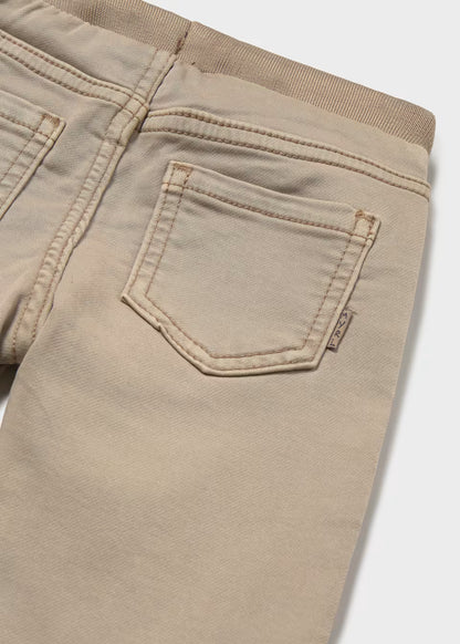 Beige Little Boy Twill Jogger Pants with two back pockets, a small fabric tag on the right pocket, and an elastic waistband. Available in sizes 2T-6T.