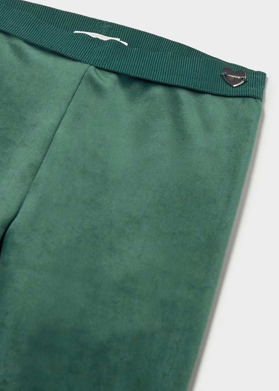 Baby Velvet Leggings in Water Lily, ultra-soft green velvet, ribbed waistband, metallic heart-shaped logo tag at top right. Available in sizes 0-3M to 24M.