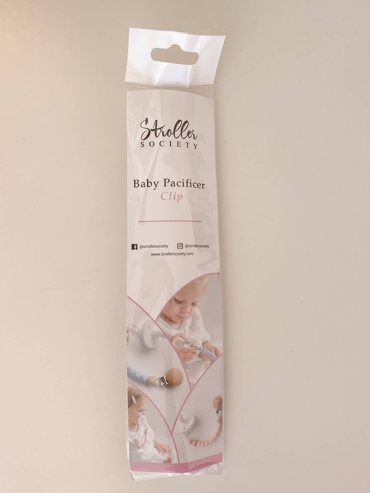 Packaging of a Pacifier Clip - Pink and Blue baby pacifier clip, featuring photos of infants using the product and social media contact information on a soft beige background. Each clip is made from BPA-free