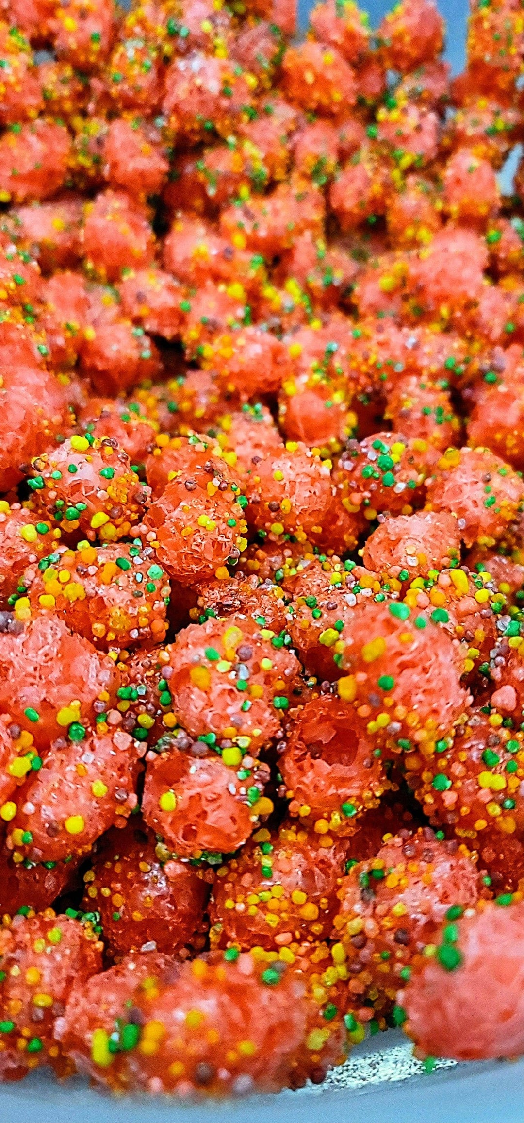 Bright red gummy candies with yellow, green, and orange sprinkles. Original Crunchy Clusters: Singles available in small and large sizes.