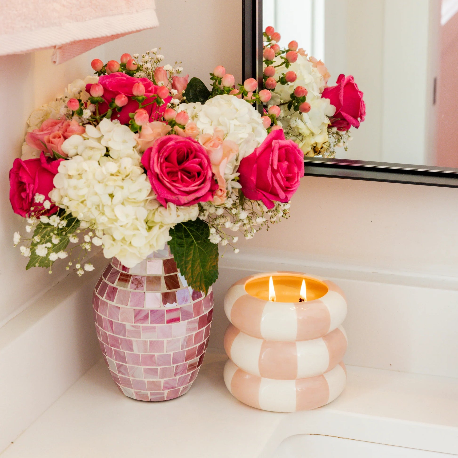 A bouquet of pink roses, white hydrangeas, and pink berries in a mosaic vase. Available in small and large sizes.