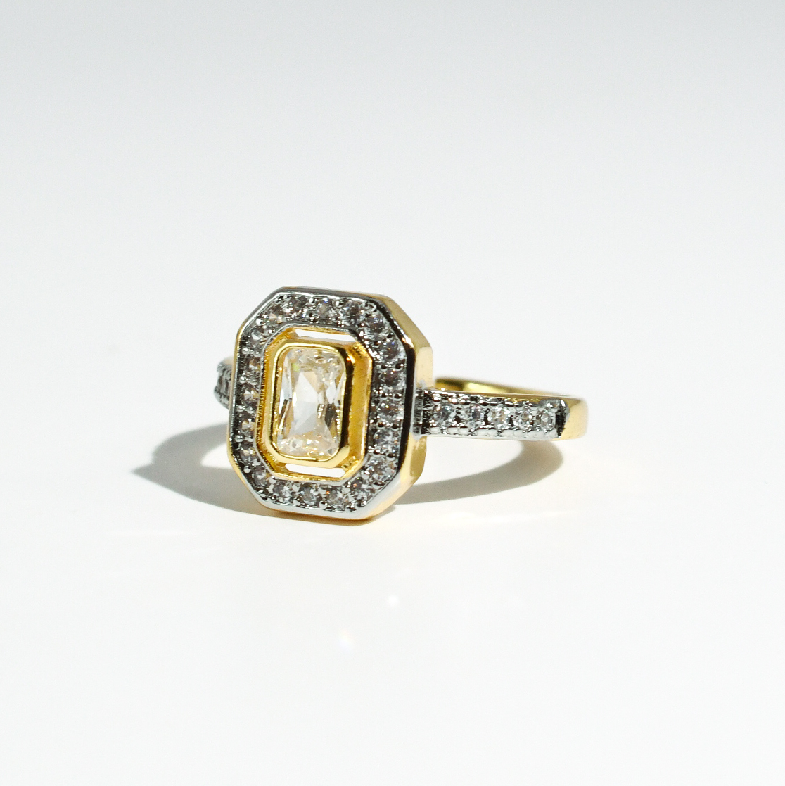 Gold-plated ring with diamond accents, rectangular center stone, double halo; available in sizes 5-9.