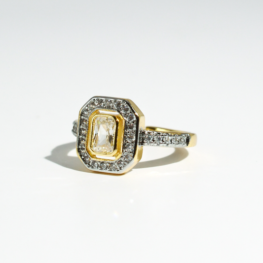 Gold-plated ring with diamond accents, rectangular center stone, double halo; available in sizes 5-9.